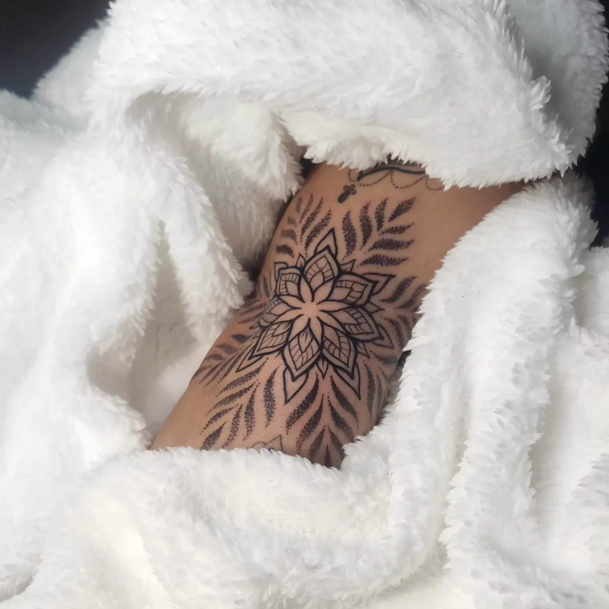 Tatuagem de mandala floral no antebraço, estilo pontilhismo, feita no Ateliê Garden