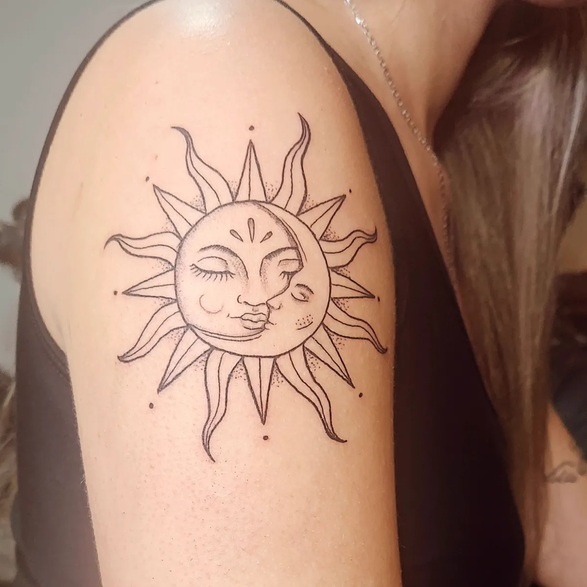 Tatuagem de sol e lua em fine line no braço, feita no Ateliê Garden